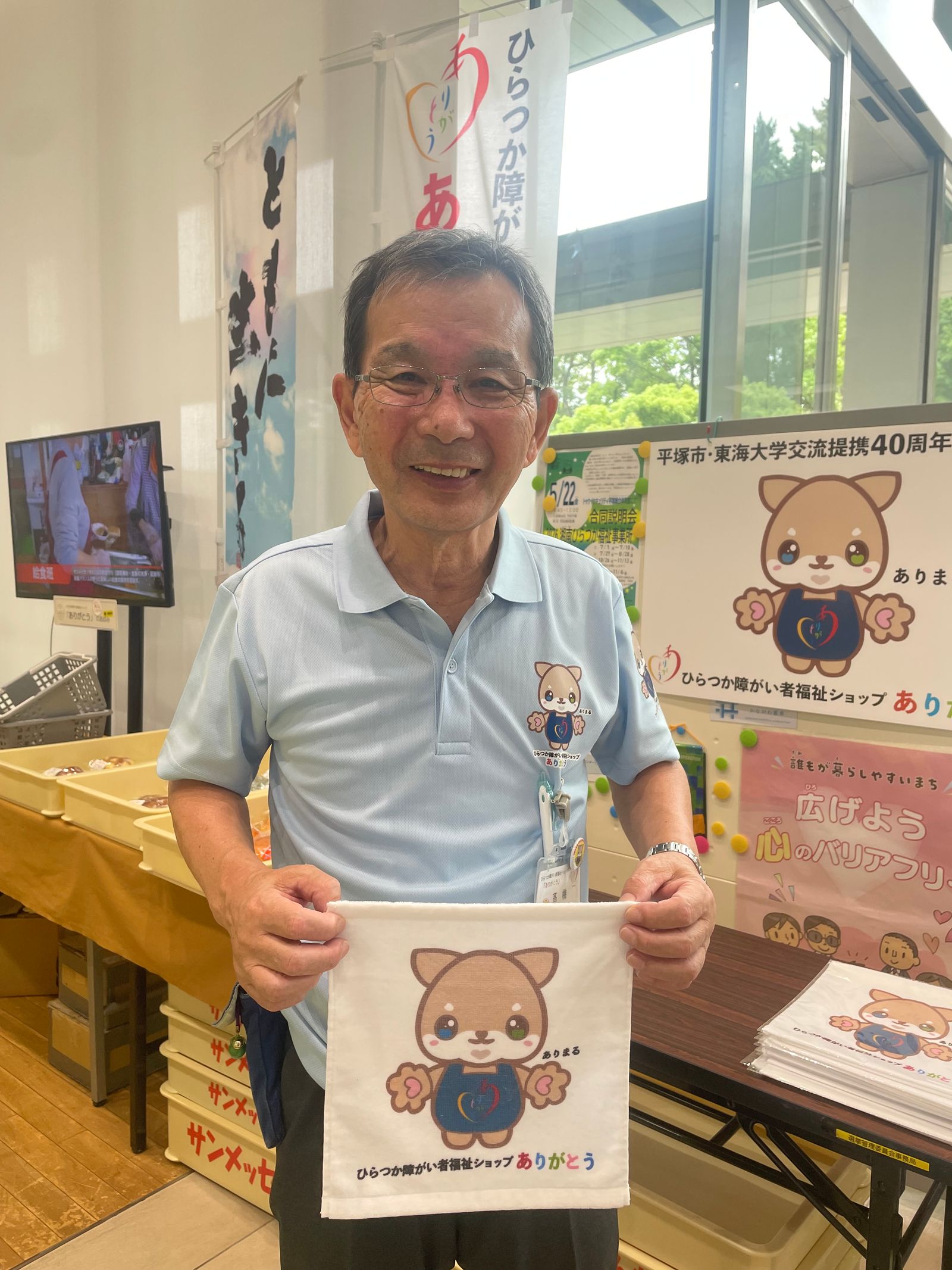 マスコットキャラクター「ありまる」のタオルを手にしたスタッフの方